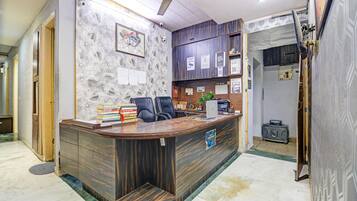Una recepción con detalles de madera, un ventilador de techo y una pared con diplomas enmarcados.
