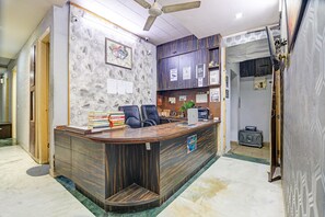 Un comptoir d’accueil avec un revêtement en bois, un ventilateur de plafond et un mur orné de certificats encadrés.