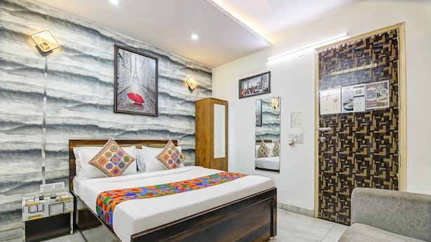 Une chambre à coucher moderne avec un lit, une table de chevet et un mur décoré d’un motif.