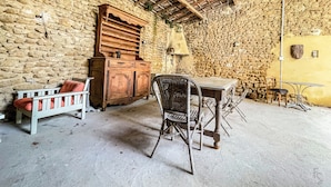 Ein rustikaler Raum mit Steinwand, Holzmöbeln und Betonboden.