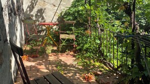 Un'area giardino con una panchina, un tavolo e una struttura a pergola.
