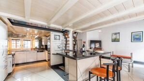 Une cuisine moderne dotée d’un îlot central, de tabourets de bar et d’un escalier menant à un niveau supérieur.