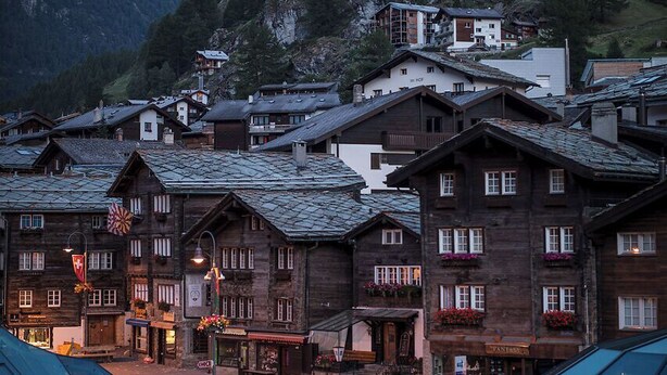 Un bâtiment traditionnel en bois, avec une chaîne de montagnes en arrière-plan.
