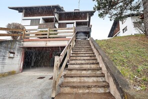 Ein mehrgeschossiges Gebäude mit einer Treppe, die zu einem überdachten Eingang führt.