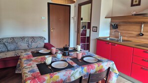 Una habitación acogedora con mantel floreado, un sofá, un aparador rojo y techo de madera.