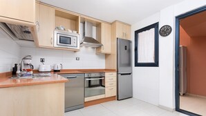 Una cocina moderna con horno empotrado, microondas y refrigerador de acero inoxidable.
