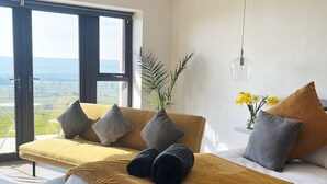 A modern bedroom with a large bed, a sofa, and a view of the outdoors. - SUPERIOR ACCOMMODATION WITH BREATHTAKING COUNTRYSIDE VIEWS (Glanton)