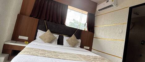 A bedroom with a large bed, wooden headboard, and a ceiling fan.