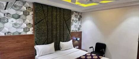 A modern bedroom with a bed, a nightstand, and a headboard with a geometric pattern.
