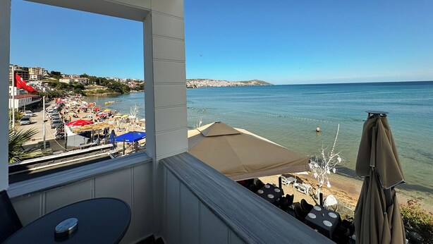 A balcony with a view of a beach and cityscape. - Beyaz Ev Hotel Restaurant (Sinop)