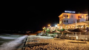A beachfront hotel with a sign reading "BEYAZ EV," featuring outdoor seating and a well-lit facade. - Beyaz Ev Hotel Restaurant (Sinop)