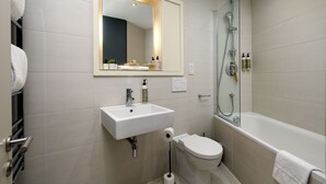 Un bagno moderno con lavandino, WC e vasca da bagno bianchi.