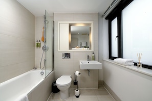 A modern bathroom with a bathtub, toilet, and sink.