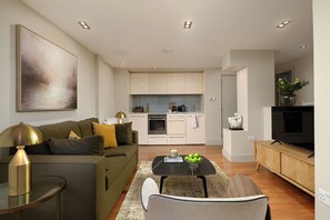A modern living room with a sofa, coffee table, and a TV.