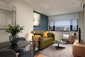 Ein modernes Wohnzimmer mit einer Couch, einem Couchtisch und einem Essbereich mit Stühlen.