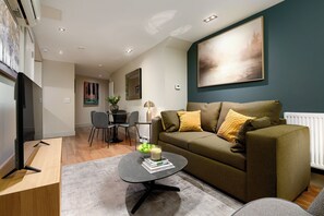 Un salon moderne avec un canapé, une table basse et un téléviseur.