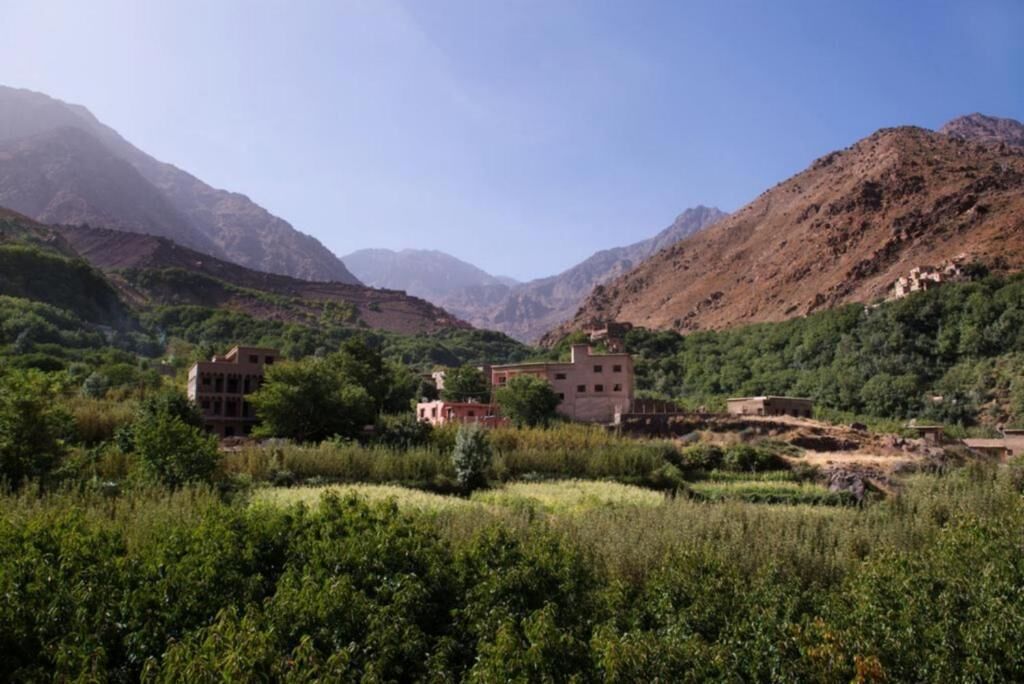 Un paisaje montañoso con varios edificios en medio de abundante vegetación.