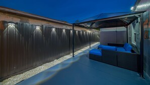 A covered outdoor seating area with a metal fence and a glass canopy.