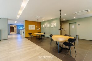 A modern interior with a dining area, a wall with motivational text, and a hallway leading to another room.