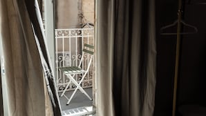 Una habitación con piso estampado, una silla de metal y un perchero.
