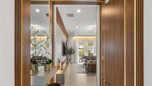 Un interior moderno con mostrador de recepción de madera, zona de estar y vistas al exterior.