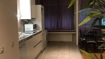 Horno, placa de cocina, utensilios de cocina y mesa de comedor
