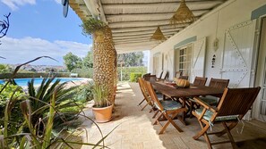 A covered outdoor dining area with a pool in the background. - Toca do Fradinho - Pera 3 7Km da Praia (Silves)