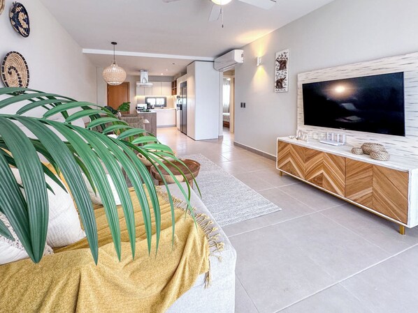 A modern living room with a sofa, TV, and decorative items.