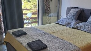 Une chambre avec un lit, un canapé et une vue sur l’extérieur.