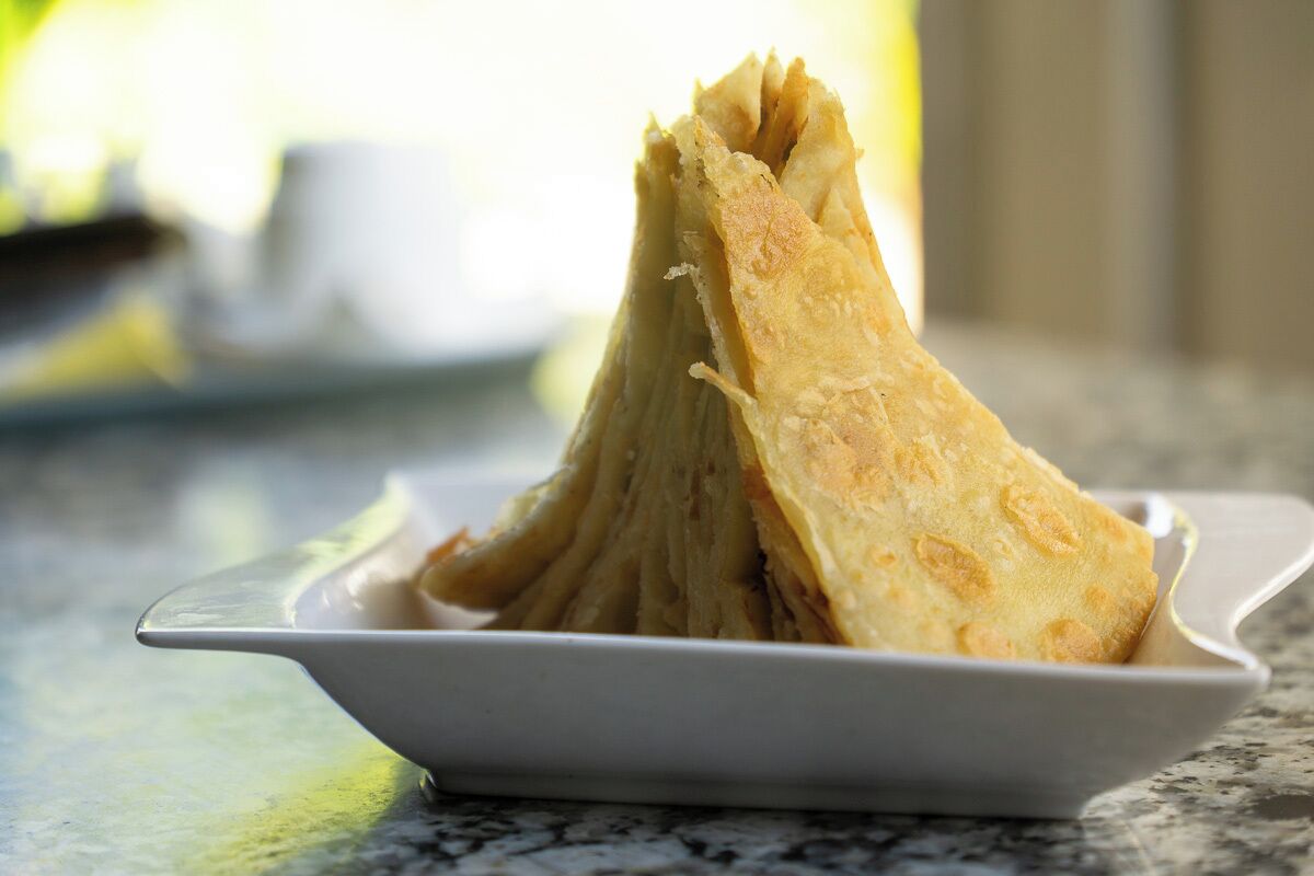 Un montón de panes planos sobre un plato blanco.