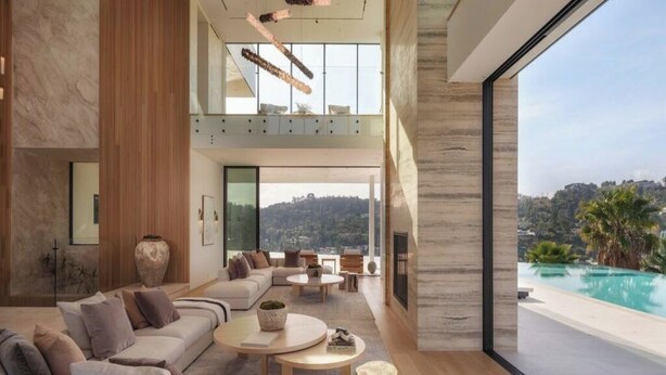 A modern living room with a large sofa, coffee tables, and a view of a pool. - Royal Oak - Exquisite Estate with Infinity Pool & Breathtaking Views (Encino)