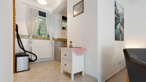 Et badeværelse med toilet, håndvask, spejl og bruseområde.