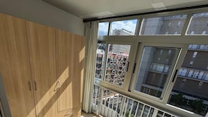 A balcony with a view of a residential building, a wooden wardrobe, and a tiled floor. - Penthouse downtown Puerto de la Cruz (Puerto de la Cruz)