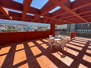 A covered outdoor area with a table and chairs, a view of the city, and a railing. - Penthouse downtown Puerto de la Cruz (Puerto de la Cruz)