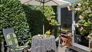 Une terrasse avec une table, des chaises et un parasol.