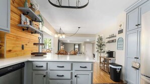 Une cuisine moderne dotée d’un îlot central, de lambris en bois et d’éléments de rangement intégrés.