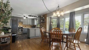 Une cuisine moderne avec des meubles en bois, un îlot central et un coin repas doté de chaises en bois.