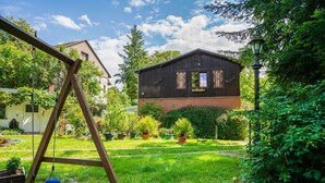 Une maison en bois avec une balançoire dans le jardin.