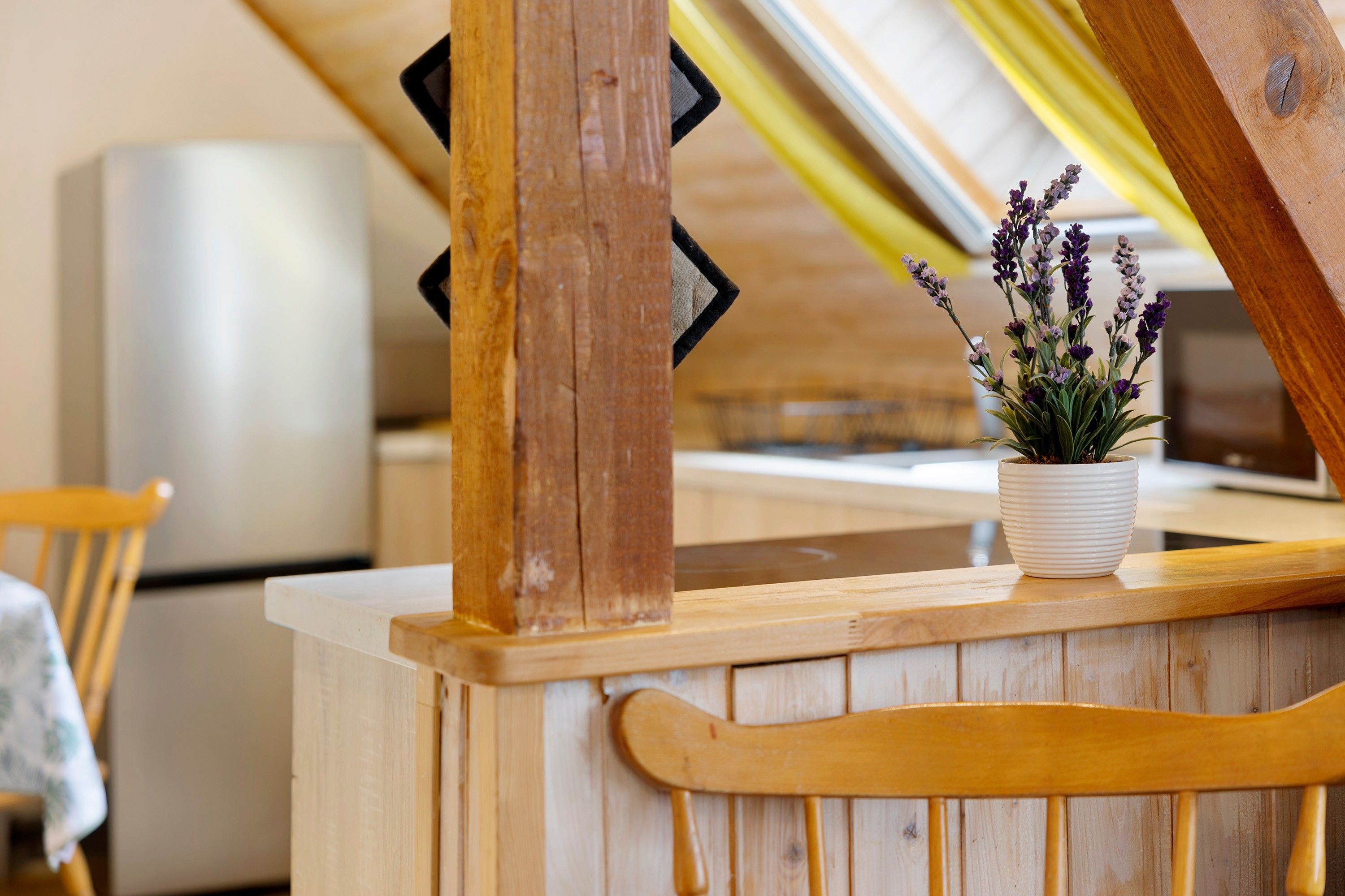 Ein Holzinterieur mit einem weißen Topf Lavendel auf einem Holztisch.