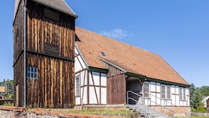 A traditional half-timbered building with a steep roof and a wooden structure.