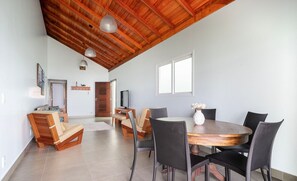 A dining area with a wooden table and chairs, a television, and a wooden ceiling. - House on the Beachfront of Pereque SC Aaf378 (Porto Belo)