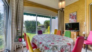 Una habitación con cama, televisión, una mesa y sillas, y vista al exterior.