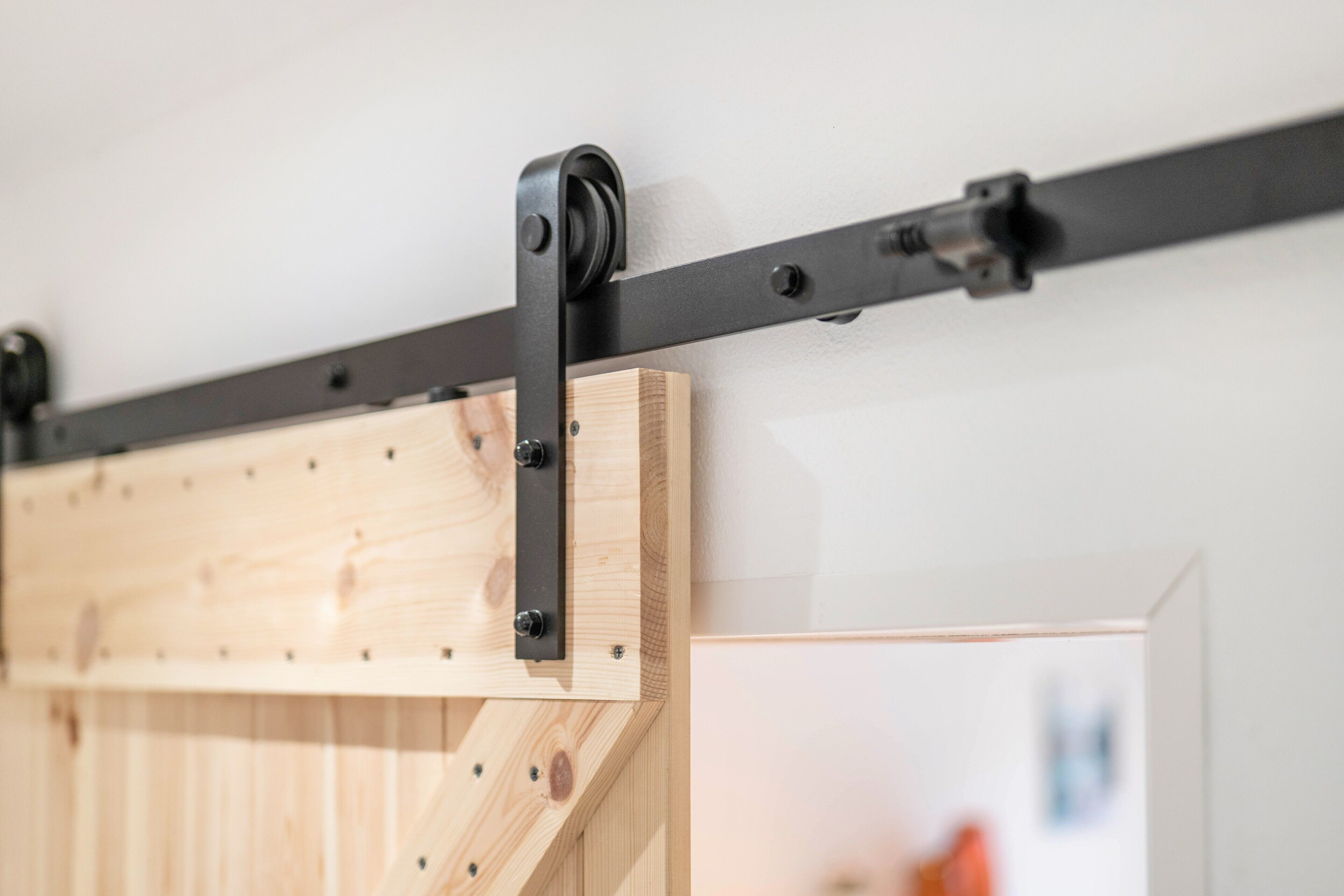 A wooden sliding barn door with metal hardware, likely part of a room's interior design.