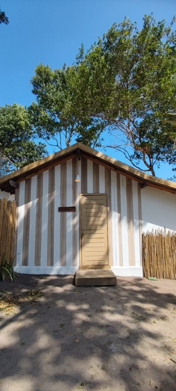 A building with a striped exterior, a wooden door, and a small porch.