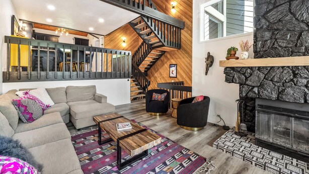 A spacious living area with a high ceiling, a staircase, a fireplace, and a cozy seating arrangement. - Ridgepoint Retreat Mountain Escape for 8 w/ Resort Amenities (Avon)