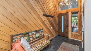 A wooden interior with a bench, a chandelier, and a door leading outside. - Ridgepoint Retreat Mountain Escape for 8 w/ Resort Amenities (Avon)