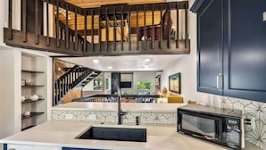 A modern kitchen with a built-in microwave, a sink, and a staircase leading to a loft area. - Ridgepoint Retreat Mountain Escape for 8 w/ Resort Amenities (Avon)