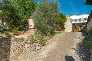 A paved driveway leading to a building with a stone wall and steps. - Studio Apartment 'La Dolce Vita' with Shared Pool, Wi-Fi and Air Conditioning (Lambesc)