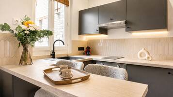 A modern kitchen with a central island, a built-in oven, and a window with a view.