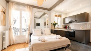 A hotel room with a bed, a bathroom, a kitchen, and a balcony. - 1536 Daumesnil (Paris)